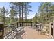 Relaxing deck with wooded views, lounge chair and seating at 7395 Heiter Hill Dr, Evergreen, CO 80439