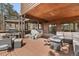 Covered deck with seating, grill, and forested views at 7395 Heiter Hill Dr, Evergreen, CO 80439