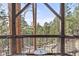 Scenic view from the deck with chairs, showcasing the lush surrounding landscape at 7395 Heiter Hill Dr, Evergreen, CO 80439