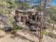 Exterior view of a multi-level home showcasing multiple decks, and wooded surroundings at 7395 Heiter Hill Dr, Evergreen, CO 80439