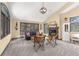 Bright living room featuring a stone fireplace, vaulted ceiling, and views of the surrounding trees at 7395 Heiter Hill Dr, Evergreen, CO 80439