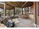 Inviting covered patio with stone flooring, timber ceiling, and views of a backyard trampoline at 7395 Heiter Hill Dr, Evergreen, CO 80439