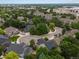 An aerial view shows a well-maintained neighborhood with mature trees and a green two-story home at 8953 W Brandt Pl, Littleton, CO 80123