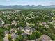 Expansive aerial view shows a well-maintained neighborhood with mature trees and a green two-story home at 8953 W Brandt Pl, Littleton, CO 80123