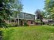 Spacious backyard with a well-maintained lawn, mature trees, and brick patio at 8953 W Brandt Pl, Littleton, CO 80123
