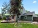 A green backyard featuring a table with an umbrella for shade, a patio, and lush landscaping at 8953 W Brandt Pl, Littleton, CO 80123