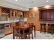 Finished basement wet bar area featuring custom cabinetry, seating, and natural lighting at 8953 W Brandt Pl, Littleton, CO 80123