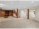 Spacious finished basement with tile flooring, seating, staircase, and bright lighting at 8953 W Brandt Pl, Littleton, CO 80123