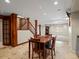 Finished basement with tile flooring, seating, staircase, and bright lighting at 8953 W Brandt Pl, Littleton, CO 80123