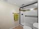 A pristine bathroom featuring a new glass shower enclosure with subway tile and bronze fixtures at 8953 W Brandt Pl, Littleton, CO 80123