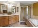 Bright bathroom boasts double sinks, a glass shower and a relaxing soaking tub at 8953 W Brandt Pl, Littleton, CO 80123