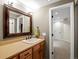 Bathroom vanity with a large framed mirror, neutral countertops, and ample cabinet space at 8953 W Brandt Pl, Littleton, CO 80123