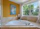 Elegant soaking tub with a scenic window view creating a relaxing spa like bathroom experience at 8953 W Brandt Pl, Littleton, CO 80123