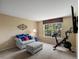 Bright bedroom featuring comfortable seating, an exercise bike and window views at 8953 W Brandt Pl, Littleton, CO 80123