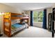 Cozy bedroom with a bunk bed, large window, and dark blue curtains at 8953 W Brandt Pl, Littleton, CO 80123