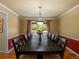 Formal dining room includes a long wooden table with seating for twelve and an elegant chandelier at 8953 W Brandt Pl, Littleton, CO 80123