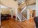 The open entryway showcases hardwood floors, a staircase, and access to the dining and kitchen areas at 8953 W Brandt Pl, Littleton, CO 80123