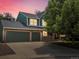 Charming two-story home features a three-car garage and a welcoming front porch at dusk at 8953 W Brandt Pl, Littleton, CO 80123