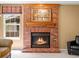 Close up on the brick fireplace with a wood mantel and painting of a city, creating a warm ambiance at 8953 W Brandt Pl, Littleton, CO 80123