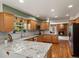 Bright kitchen features granite counters, wood cabinets, and seamlessly flows into living area with cozy fireplace at 8953 W Brandt Pl, Littleton, CO 80123
