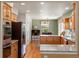 Well-lit kitchen with wooden cabinets, granite countertops, stainless steel appliances, and an open dining area at 8953 W Brandt Pl, Littleton, CO 80123