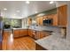 Bright kitchen featuring granite counters, wooden cabinetry, and seamlessly connects to a cozy dining area at 8953 W Brandt Pl, Littleton, CO 80123