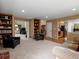 Open-concept living room featuring built-in bookshelves, plush seating, and seamless transitions to other areas at 8953 W Brandt Pl, Littleton, CO 80123
