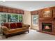 Inviting living room with brick fireplace, large windows with valances, and plush seating at 8953 W Brandt Pl, Littleton, CO 80123