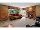 Cozy living room with a brick fireplace, large windows, and comfortable seating creating a welcoming atmosphere at 8953 W Brandt Pl, Littleton, CO 80123