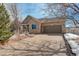 House exterior with stone accents, driveway, and snow-covered landscaping at 3008 Mountain Sky Dr, Castle Rock, CO 80104