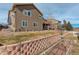 Back of house showing a deck, retaining wall, and garden area with mountain views at 3008 Mountain Sky Dr, Castle Rock, CO 80104