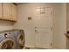 Laundry room with washer, dryer, cabinets, and access door at 3008 Mountain Sky Dr, Castle Rock, CO 80104