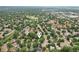 Aerial view of a neighborhood with tree-lined streets and homes on a sunny day with locator pin at 6514 Zinnia St, Arvada, CO 80004