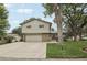 Traditional home with a spacious driveway, attached garage, and a well-manicured front lawn at 6514 Zinnia St, Arvada, CO 80004