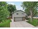 Two-story home with a long driveway and a well-manicured lawn on a sunny day at 6514 Zinnia St, Arvada, CO 80004