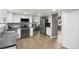 Modern kitchen with stainless steel appliances, white cabinets, stone countertops and wood flooring at 6514 Zinnia St, Arvada, CO 80004