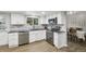 Well-lit kitchen featuring stainless steel appliances, marble backsplash, and access to the dining area at 6514 Zinnia St, Arvada, CO 80004