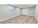 Spacious basement area with wood-look flooring, closet, built in shelves, and natural light from a window at 101 S 11 Ave, Brighton, CO 80601