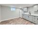 Kitchenette area with grey cabinets, white countertop, stainless steel refrigerator, and wood-look flooring at 101 S 11 Ave, Brighton, CO 80601