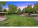 Expansive backyard featuring a well-manicured lawn, mature trees, and a charming pergola, perfect for outdoor entertaining at 5735 Big Canon Dr, Greenwood Village, CO 80111
