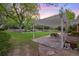 Backyard with a pergola, picnic table, patio, large tree, landscaping and green grass at 5735 Big Canon Dr, Greenwood Village, CO 80111