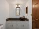Small bathroom featuring vessel sink, dark stone backsplash, and dark wood door at 5735 Big Canon Dr, Greenwood Village, CO 80111