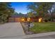 Charming brick home featuring a well-manicured lawn, mature trees, and a two-car garage at 5735 Big Canon Dr, Greenwood Village, CO 80111