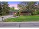 Inviting single-story home with a brick facade, well-maintained landscaping, mature trees, and a three-car garage at 5735 Big Canon Dr, Greenwood Village, CO 80111