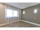 Simple bedroom with wood-look floors and sheer curtains at 9195 E Lehigh Ave # 151, Denver, CO 80237