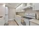 Updated kitchen featuring white cabinets and an electric stove at 9195 E Lehigh Ave # 151, Denver, CO 80237