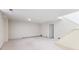 Unfinished basement featuring neutral carpet, white walls, and access to a storage area at 372 Vance St, Lakewood, CO 80226