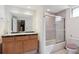 Bathroom with a tile shower, vanity, large mirror, and toilet with a purple seat cover at 372 Vance St, Lakewood, CO 80226