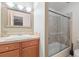 Bathroom featuring a vanity, a decorative mirror, and a tiled shower with glass doors at 372 Vance St, Lakewood, CO 80226