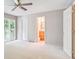 Bright bedroom with white carpet, sliding doors to a balcony, and ensuite bathroom at 372 Vance St, Lakewood, CO 80226